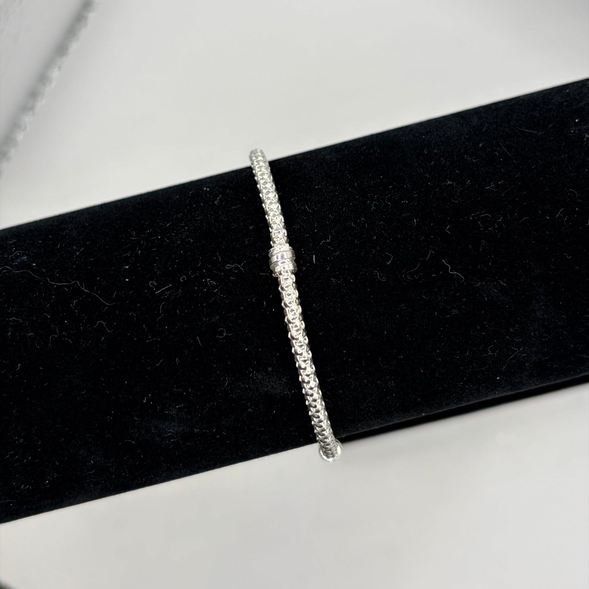 CURATED by Kira Pandora sterling silver bracelet with textured bead and pave detailing on a black display stand
