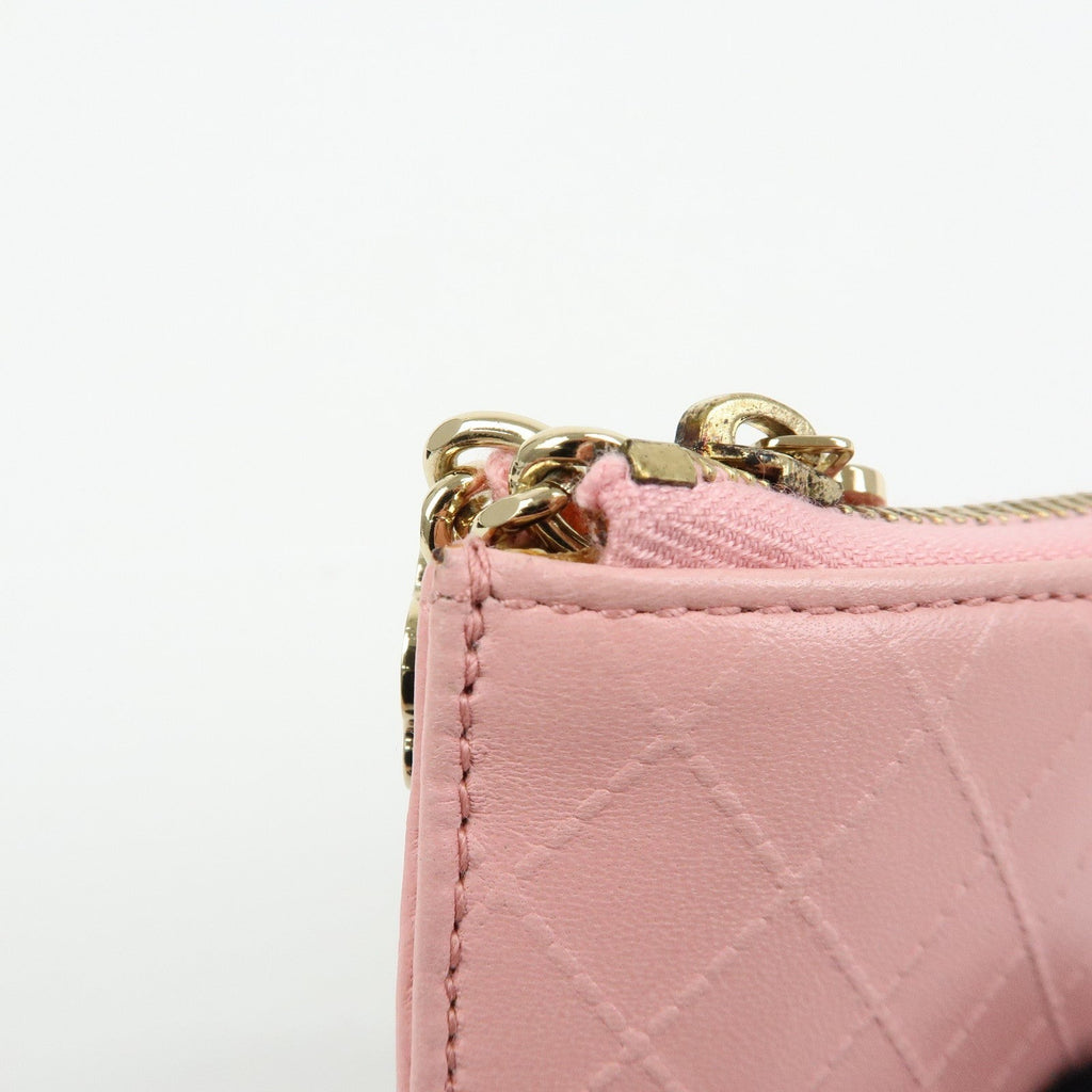 CURATED by Kira pink quilted leather zip-around card holder with gold hardware and floral charm.