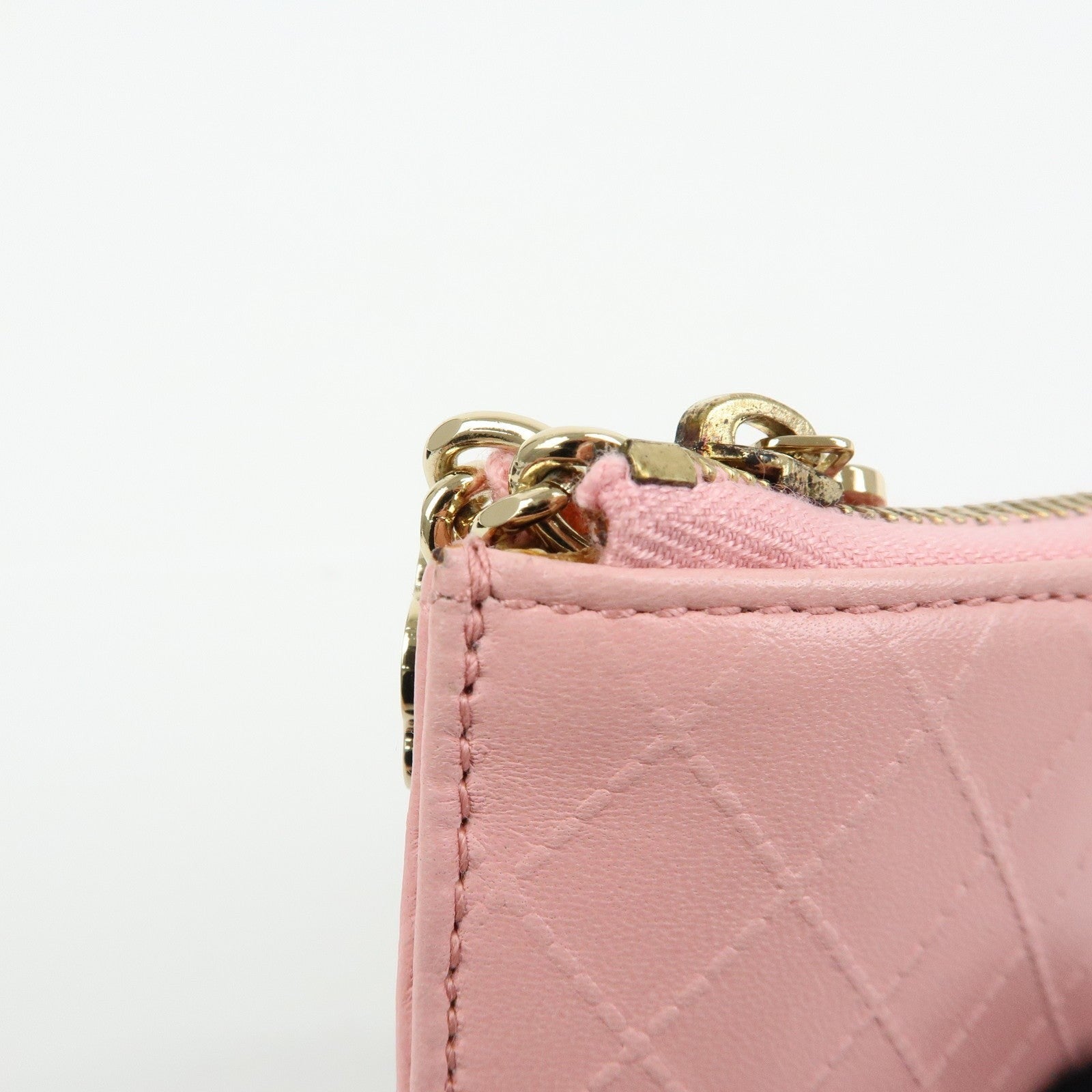CURATED by Kira pink quilted leather zip-around card holder with gold hardware and floral charm.