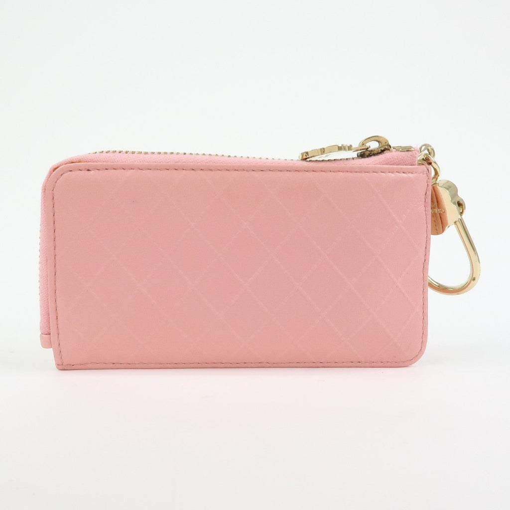 CURATED by Kira pink quilted leather zip-around card holder with floral charm and gold hardware.