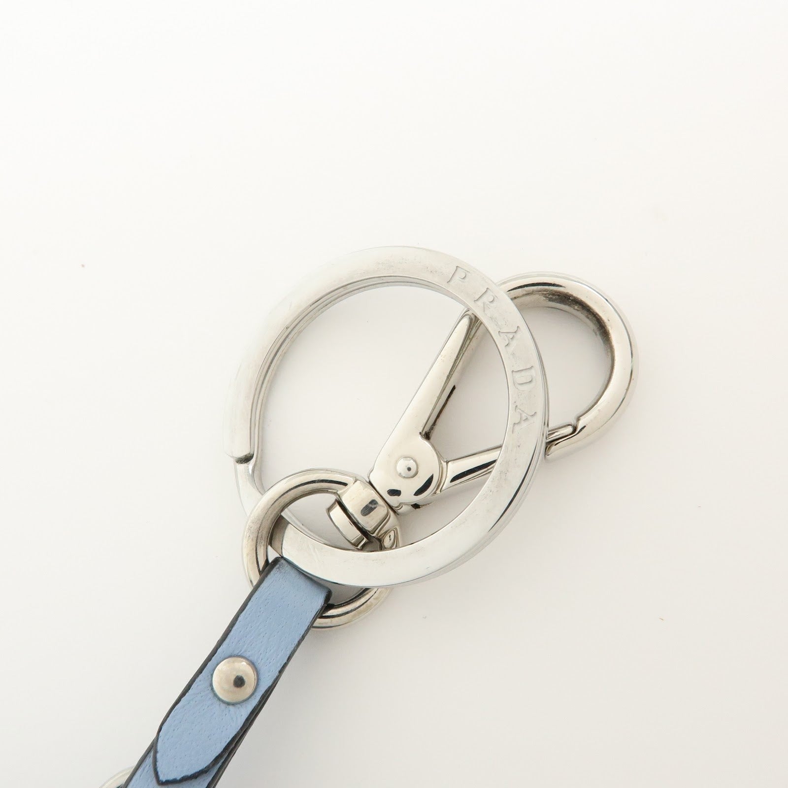 CURATED by Kira light blue Saffiano leather dolphin charm keychain with silver-tone hardware and Prada triangle logo.