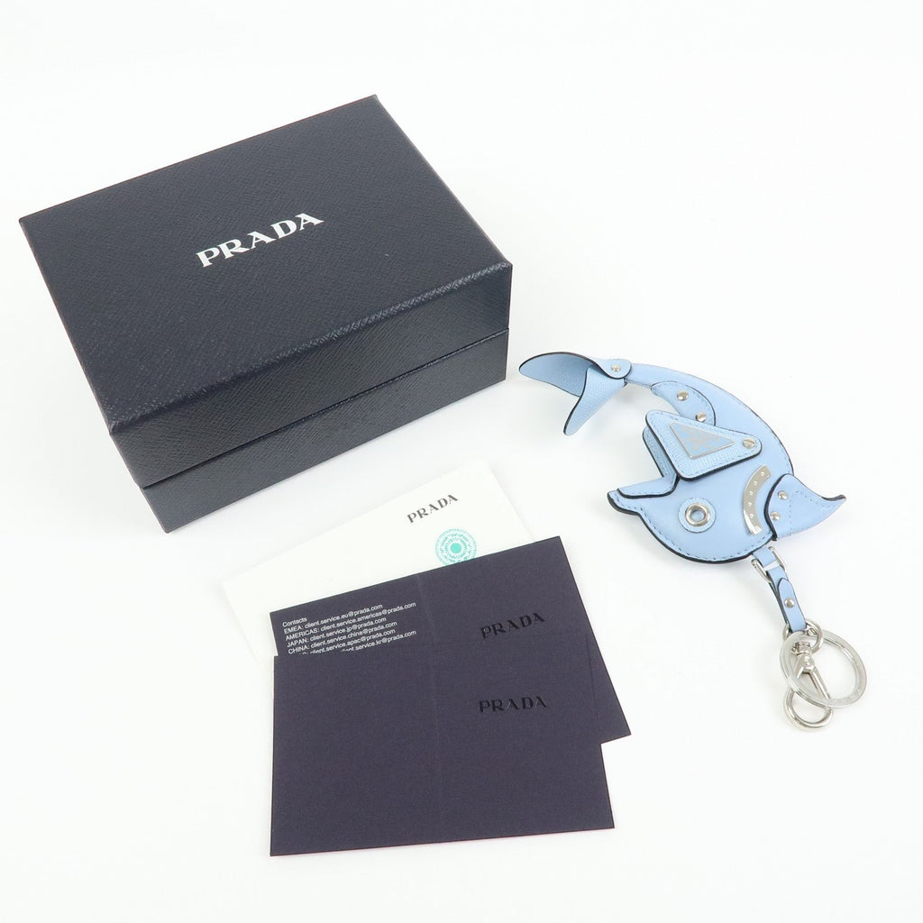 CURATED by Kira light blue Saffiano leather dolphin charm with Prada triangle logo and silver hardware, includes box and authenticity cards.