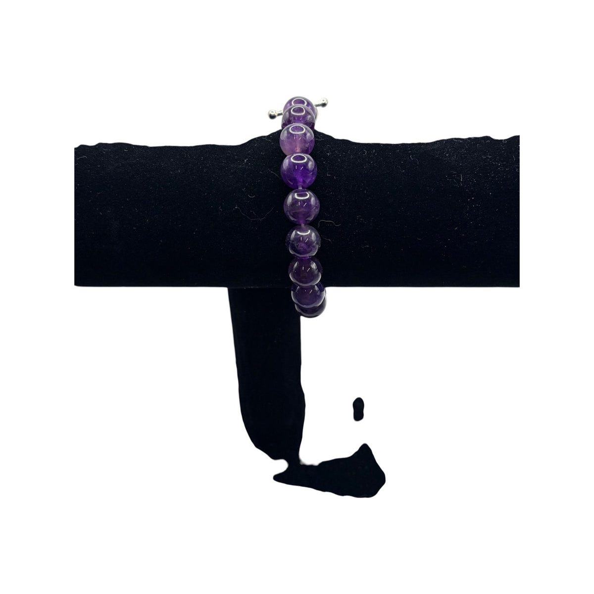 CURATED by Kira purple faceted bead bracelet with a silver toggle clasp displayed on a black velvet stand