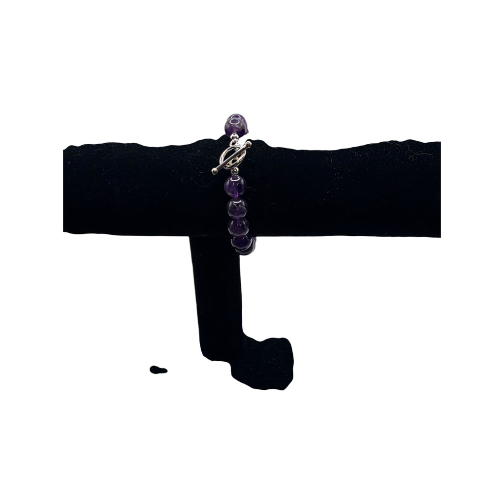 CURATED by Kira purple and gray faceted bead bracelet with a silver toggle clasp on a black display stand