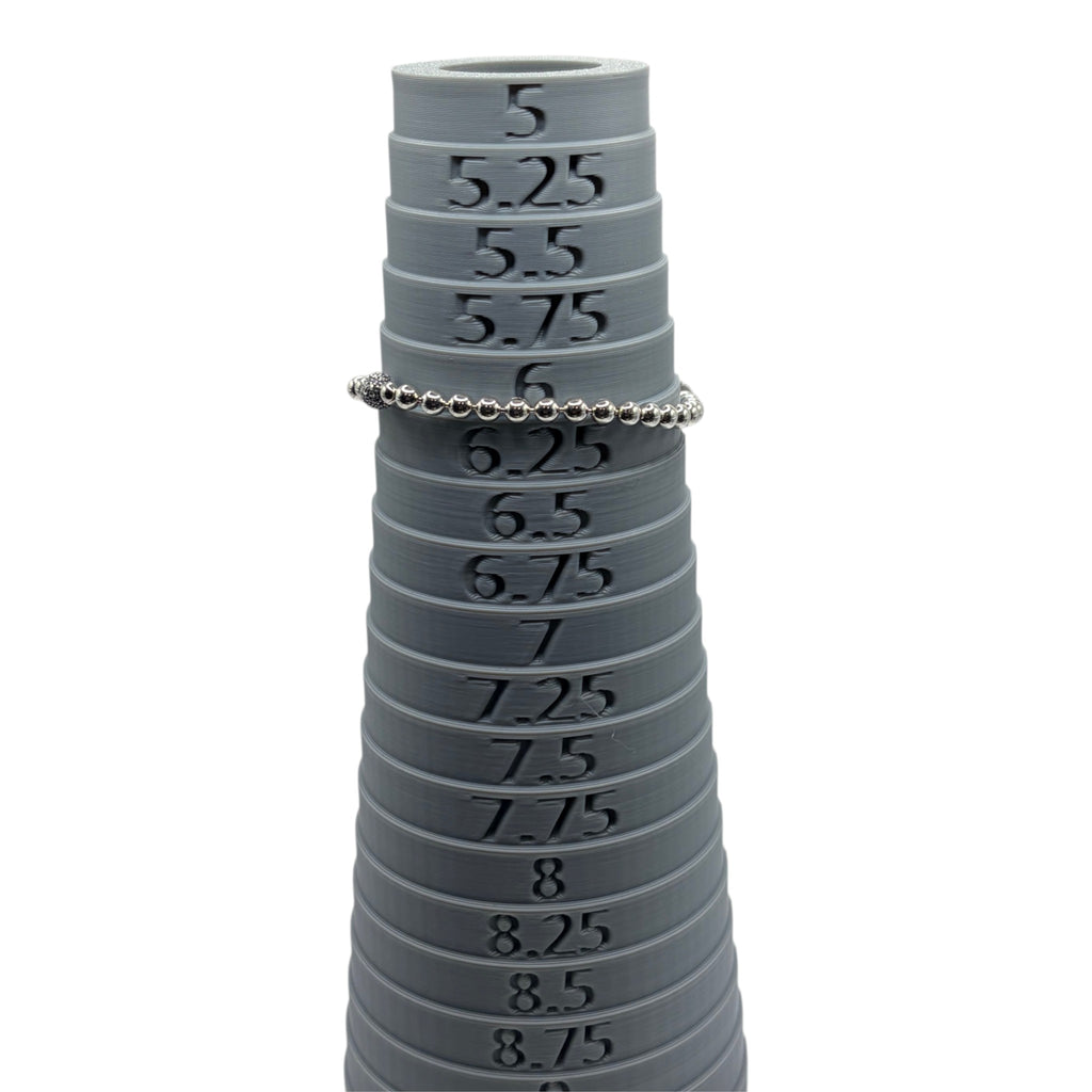 CURATED by Kira silver tone beaded bracelet with pave crystal ball accent resting on a grey ring sizing mandrel