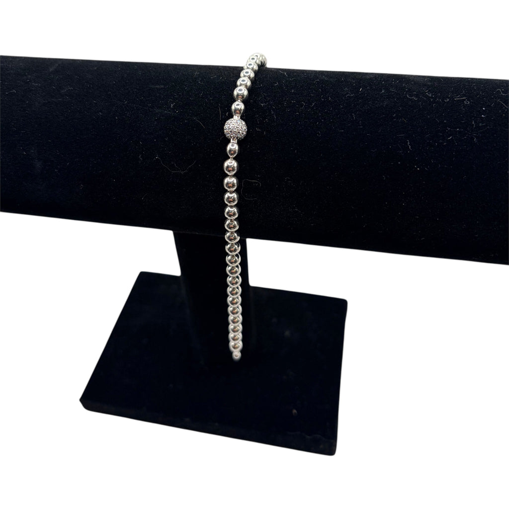 CURATED by Kira silver tone beaded bracelet featuring a central pave crystal ball accent on a black display stand