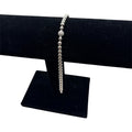 CURATED by Kira silver tone beaded bracelet featuring a central pave crystal ball accent on a black display stand