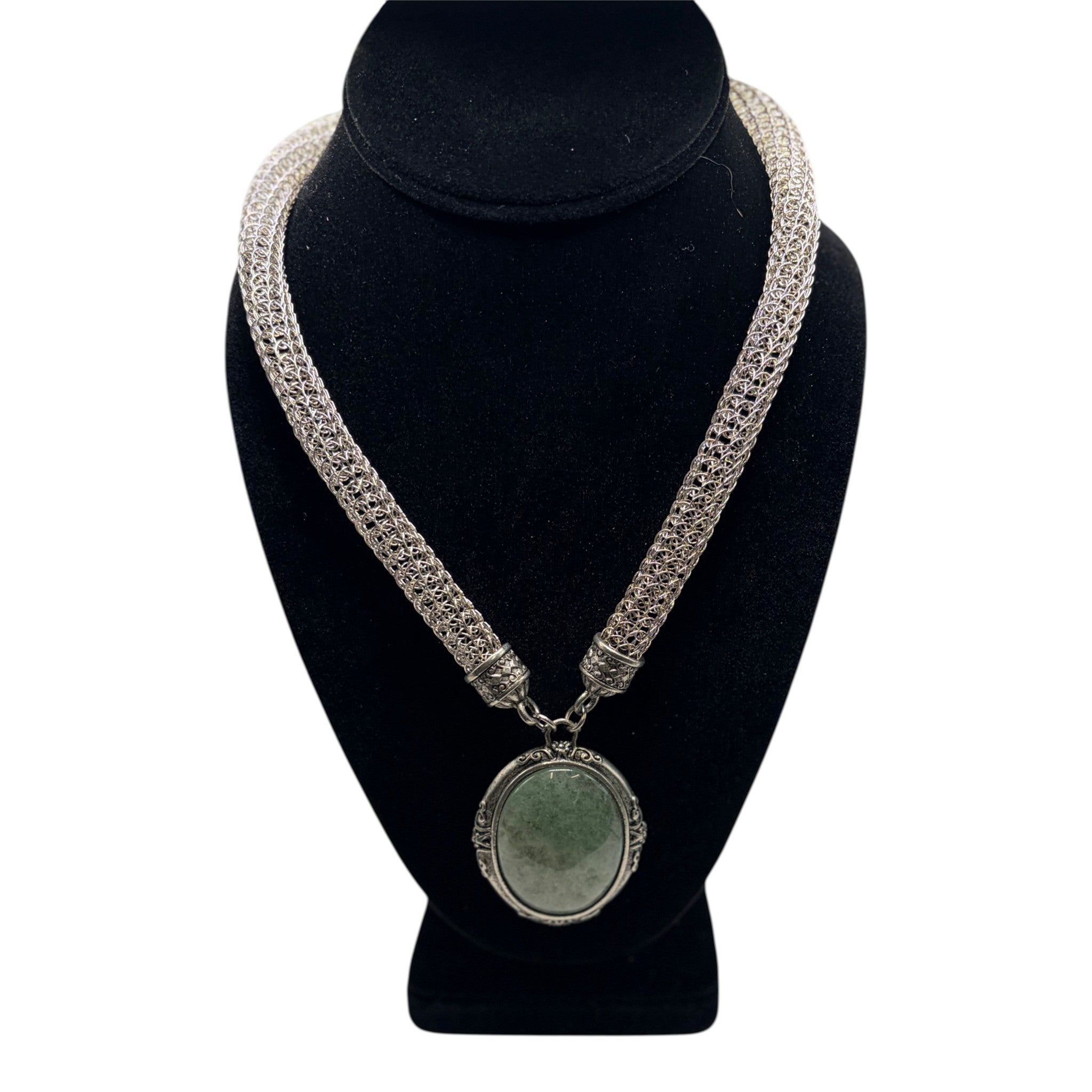 CURATED by Kira 1928 silver tone mesh choker necklace with an ornate oval green gemstone pendant on a display bust