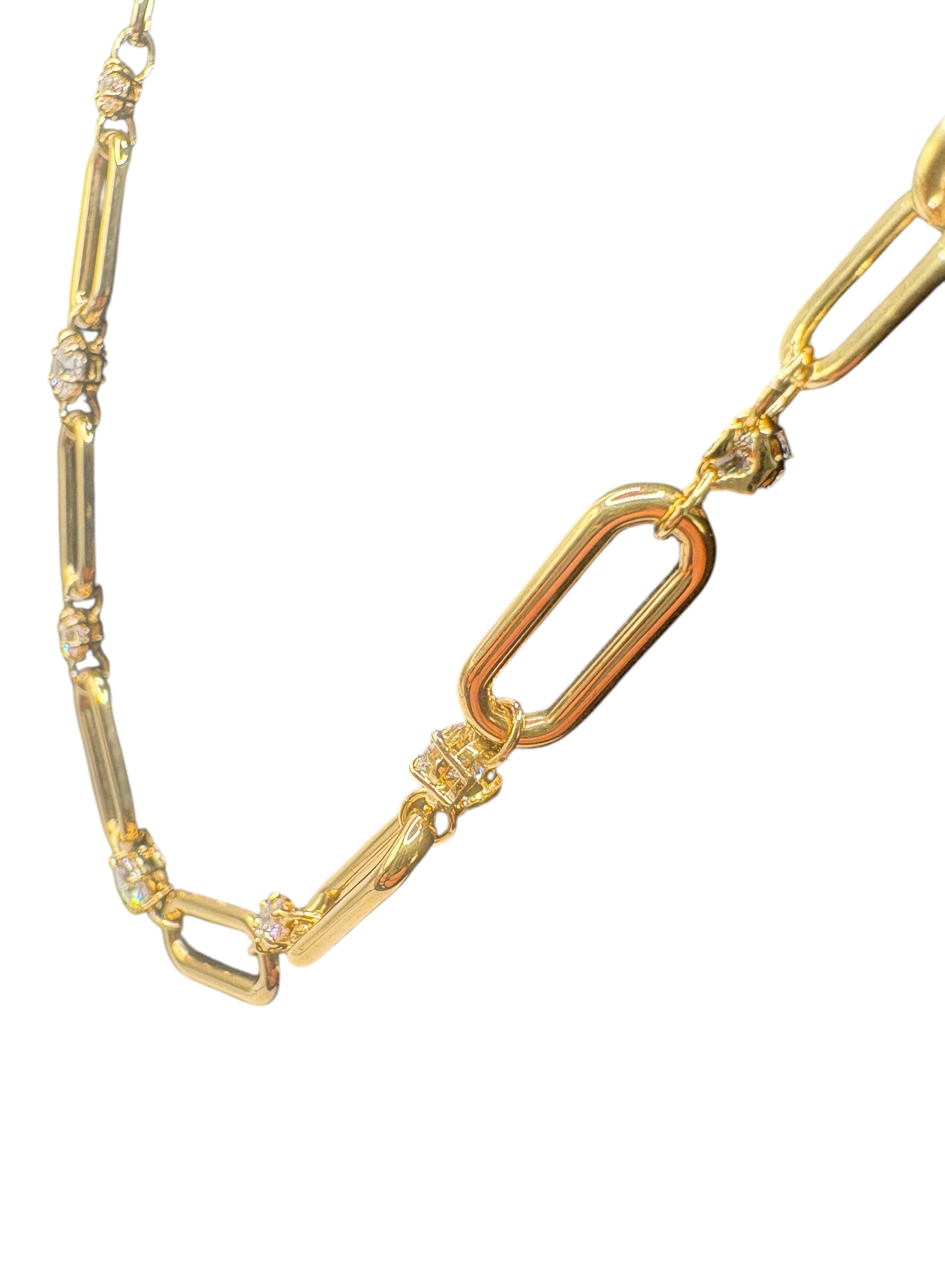 CURATED by Kira Swarovski Dextera gold-tone paperclip necklace with sparkling white crystal accents on a black bust