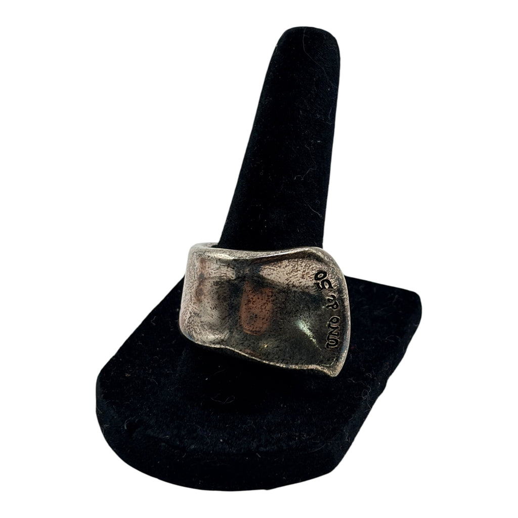 CURATED by Kira Uno de 50 oxidized silver chunky ring with an organic freeform design on a black display stand.