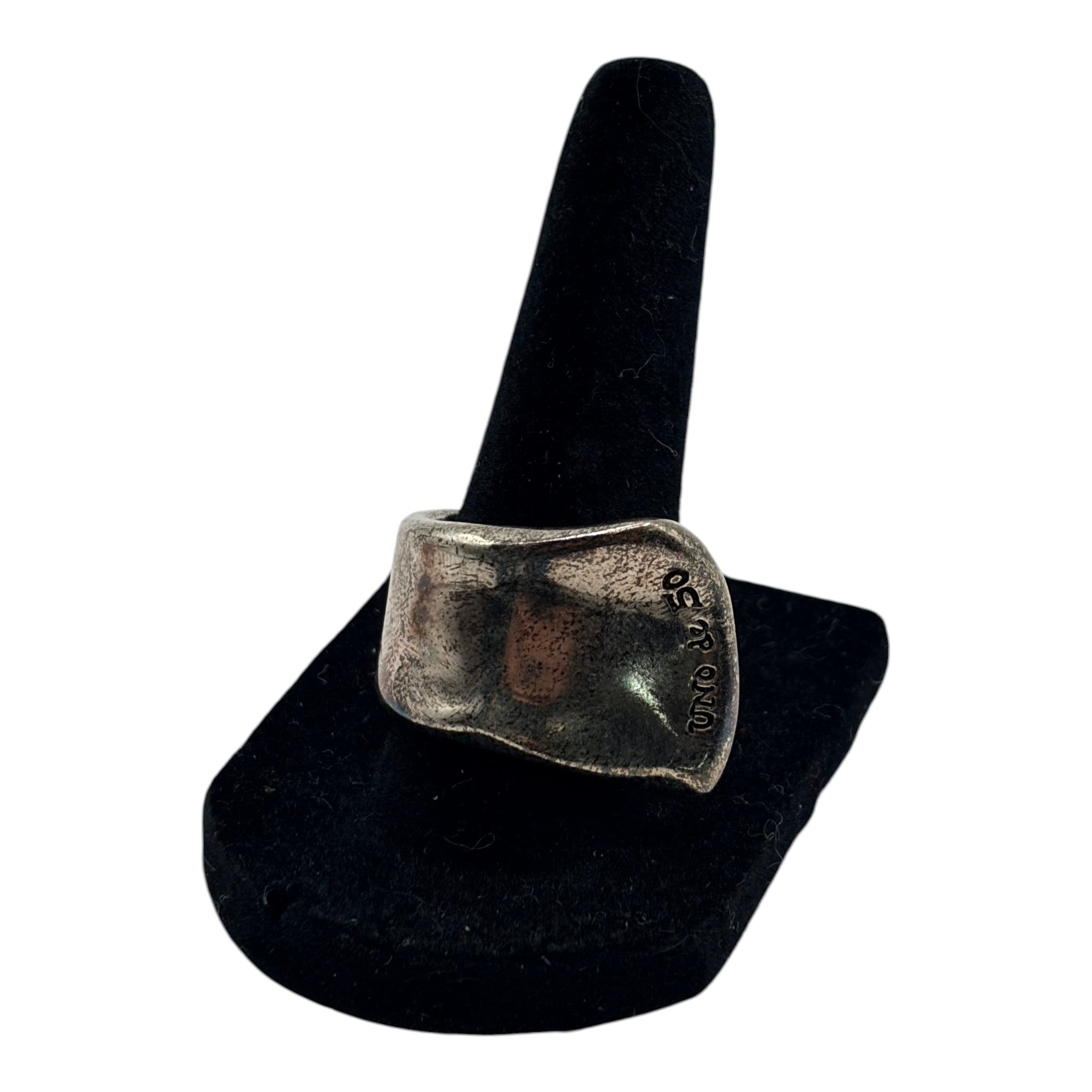CURATED by Kira Uno de 50 style chunky oxidized silver ring with an organic freeform shape on a black display stand.