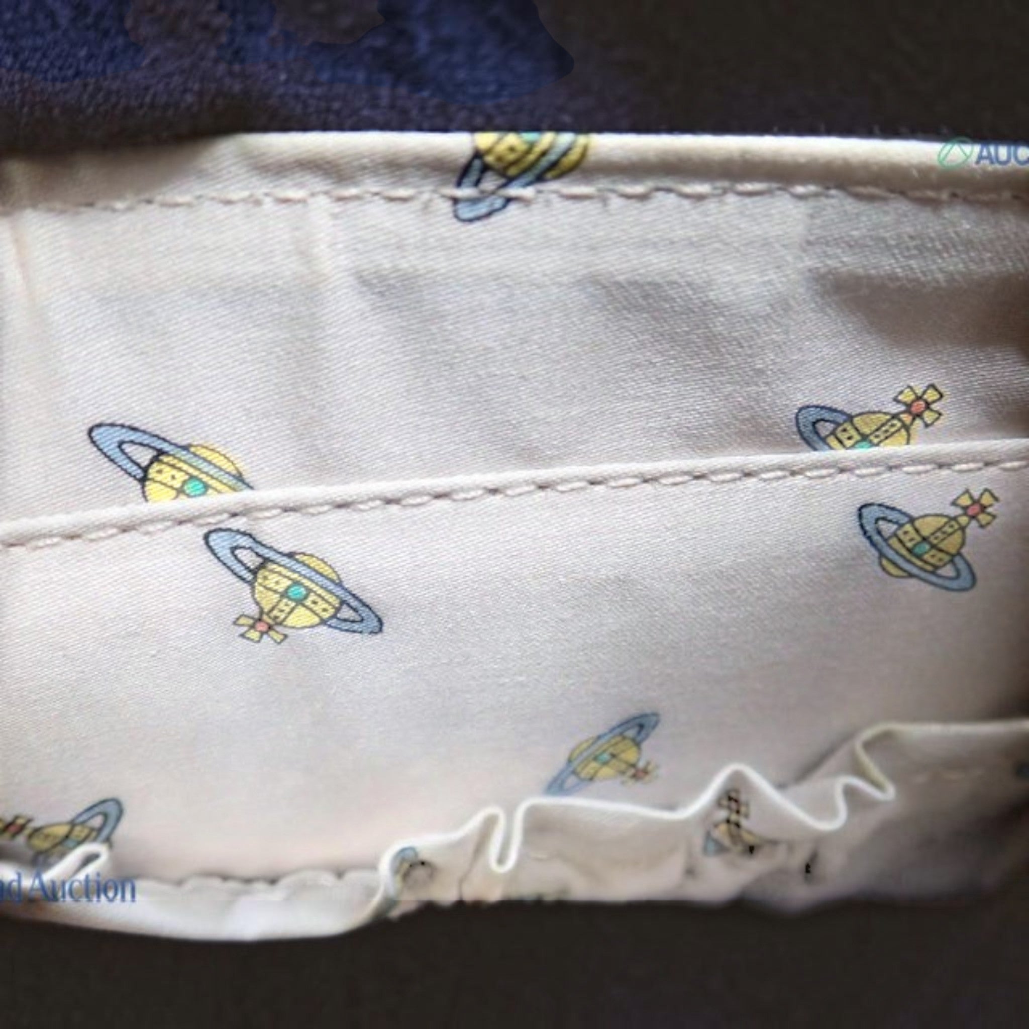 CURATED by Kira Vivienne Westwood handbag interior featuring beige fabric with signature Saturn orb logo print