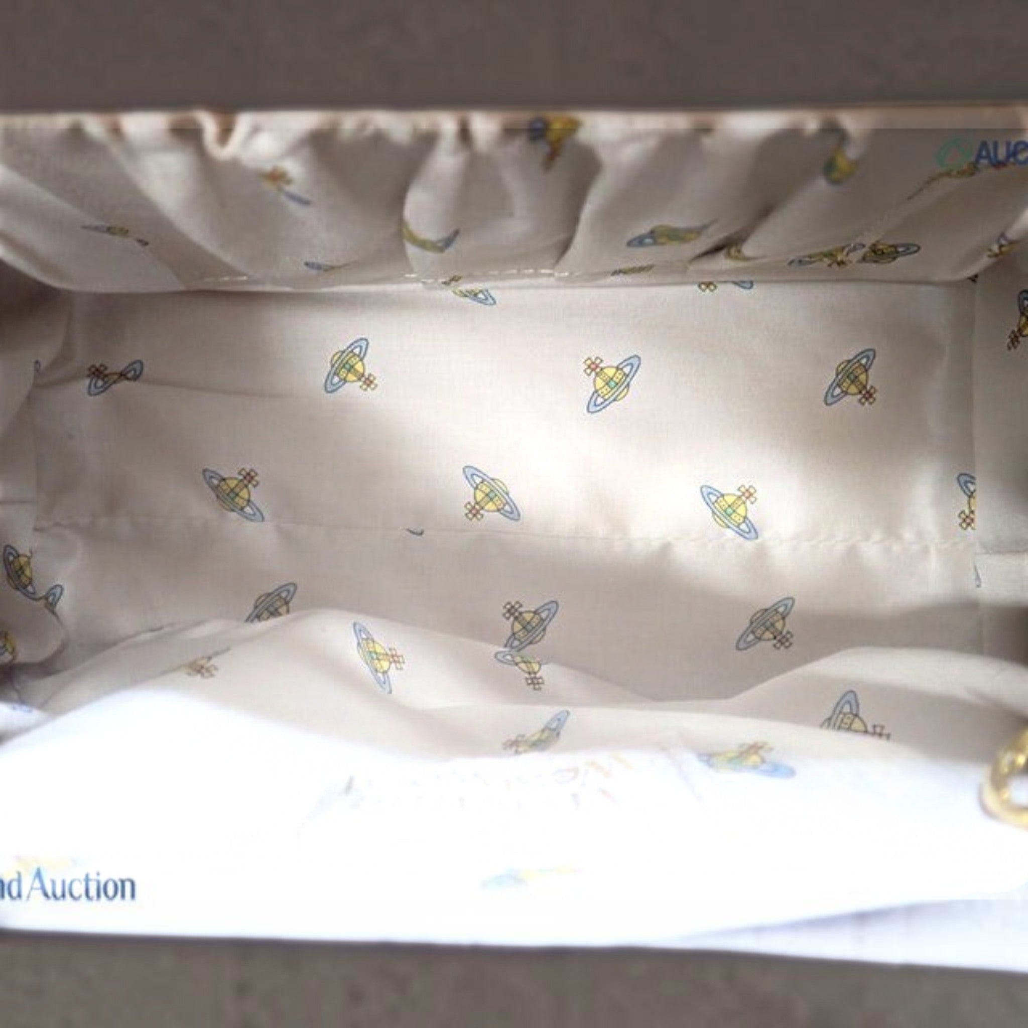CURATED by Kira Vivienne Westwood enamel handbag interior featuring cream fabric lining with iconic orb logo pattern
