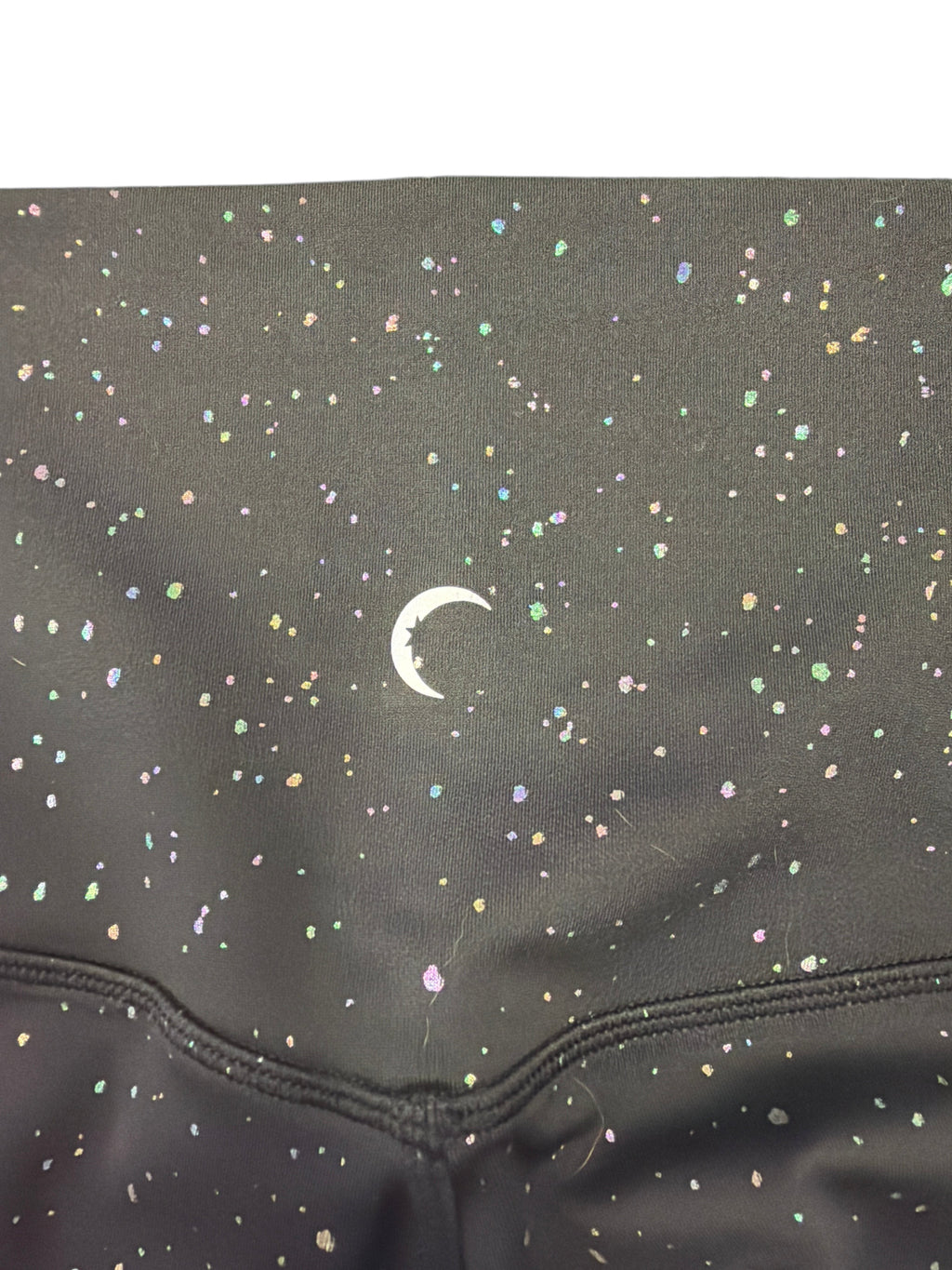 CURATED by Kira ZYIA Active black high-waisted leggings featuring an iridescent metallic speckle pattern and logo.