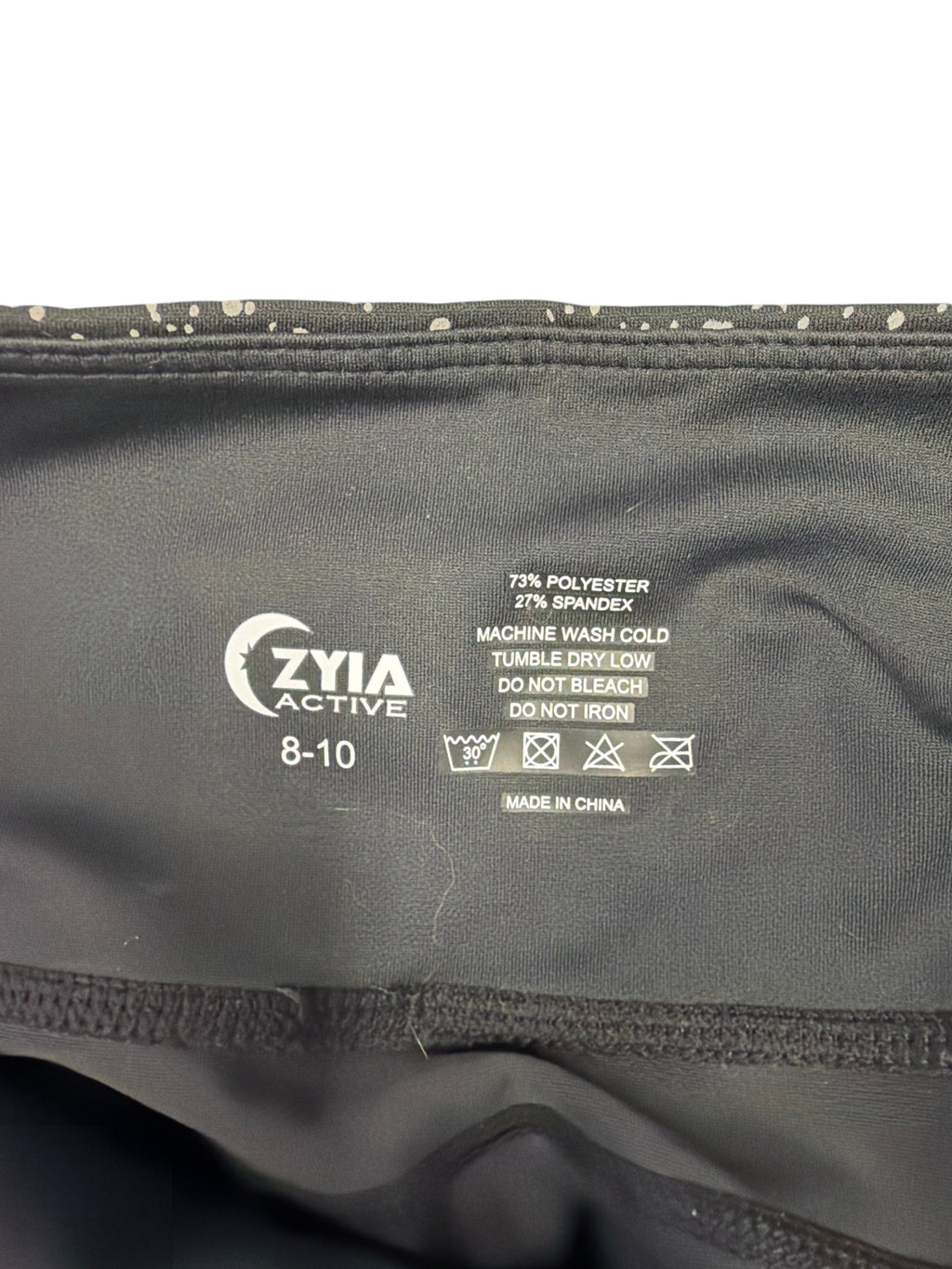 CURATED by Kira Zyia Active leggings interior label showing size 8-10, fabric blend, and care instructions.