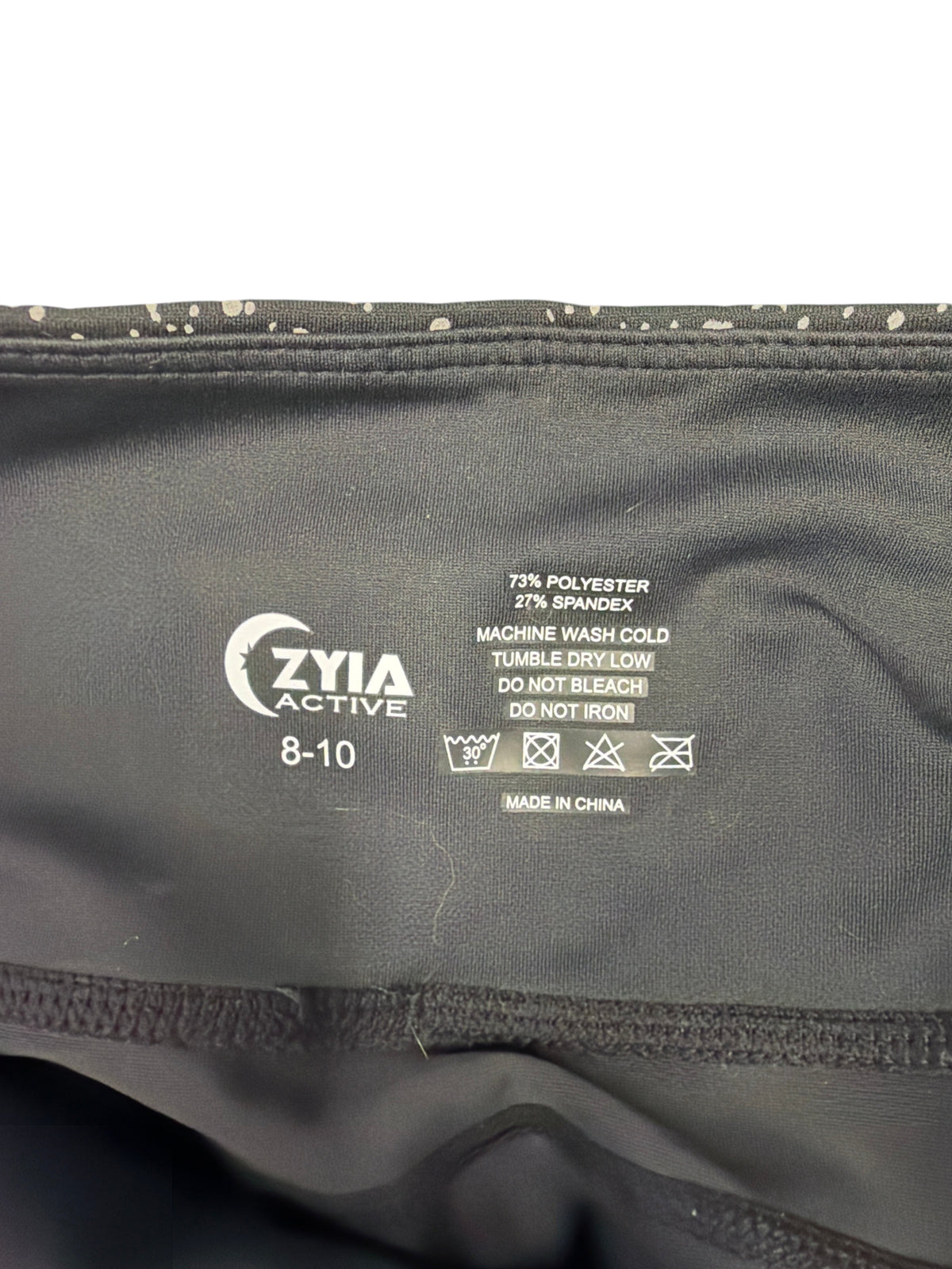 CURATED by Kira Zyia Active leggings interior label showing size 8-10, fabric blend, and care instructions.